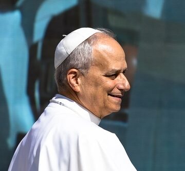Pope Leo XIV smiling while wearing traditional papal vestments and a white zucchetto cap. Pope Leo XIV smiling while wearing traditional papal vestments and a white zucchetto cap.