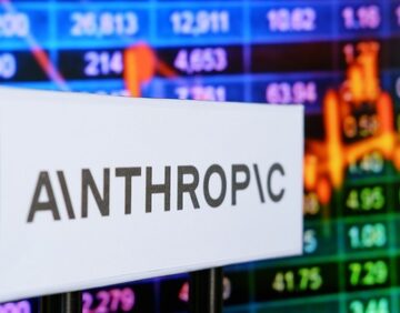 The image shows a sign for Anthropic, the American artificial intelligence startup known for developing the Claude AI model family, set against a stock market ticker background. The image shows a sign for Anthropic, the American artificial intelligence startup known for developing the Claude AI model family, set against a stock market ticker background.