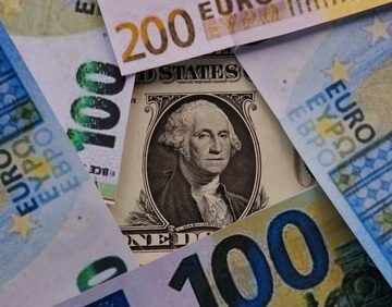 Various Euro banknotes surrounding a single U.S. dollar bill featuring George Washington.