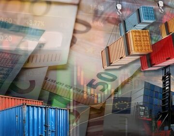 Concept image of stacks of multi-colored shipping containers, a crane/forklift loading system, and European currency notes layered into a financial market background. Concept image of stacks of multi-colored shipping containers, a crane/forklift loading system, and European currency notes layered into a financial market background.
