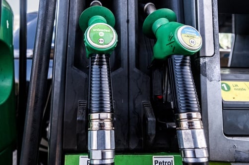 Green fuel pump nozzles and handles labeled for petrol at a service station. Green fuel pump nozzles and handles labeled for petrol at a service station.