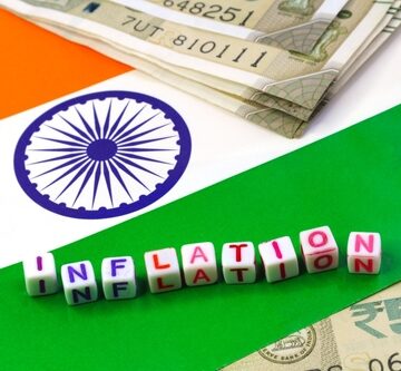 Dice spell out the word "Inflation" against a backdrop of India's flag and currency. Dice spell out the word "Inflation" against a backdrop of India's flag and currency.