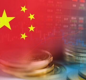 The national flag of China, stacks of coins, and a digital stock market or financial trend graph. The national flag of China, stacks of coins, and a digital stock market or financial trend graph.
