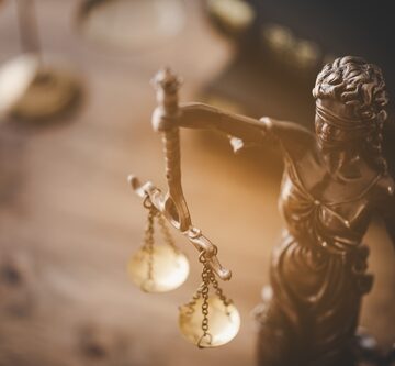 A statuette of Lady Justice, a classical allegorical symbol representing the impartial administration of law and fairness.