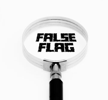 A magnifying glass focused on the text "FALSE FLAG."