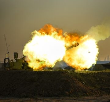 A heavy live-fire launch or detonation near a structure displaying an Israeli flag. A heavy live-fire launch or detonation near a structure displaying an Israeli flag.