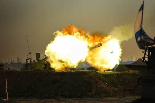 A heavy live-fire launch or detonation near a structure displaying an Israeli flag. A heavy live-fire launch or detonation near a structure displaying an Israeli flag.