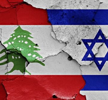 The national flags of Lebanon and Israel separated by a cracks. The national flags of Lebanon and Israel separated by a cracks.