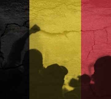 Graphic overlay of the vertical tricolor Flag of Belgium set against a cracked texture with silhouettes of protesting people raising fists.