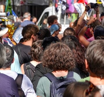 A diverse crowd of people gathered outdoors, possibly during a protest.